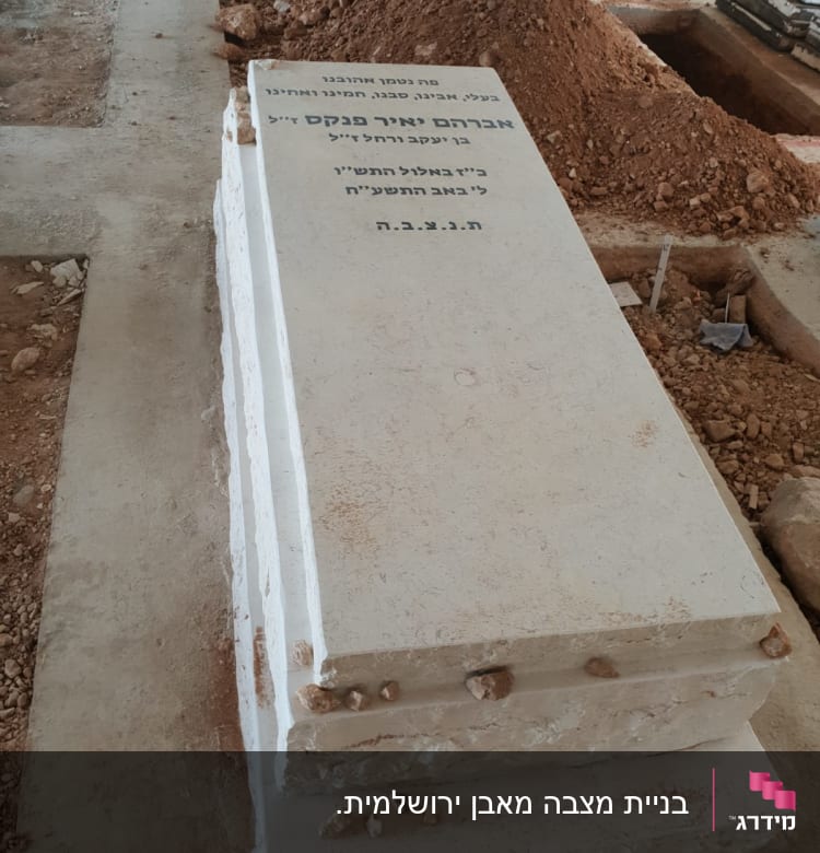 מצבה לבנה עם כיתוב בעברית בבית קברות